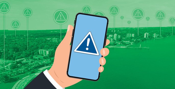 Hand holding cell phone receiving emergency alert