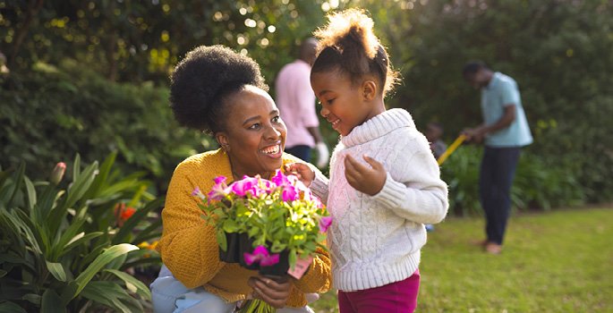 Daughter and mother planting flowers