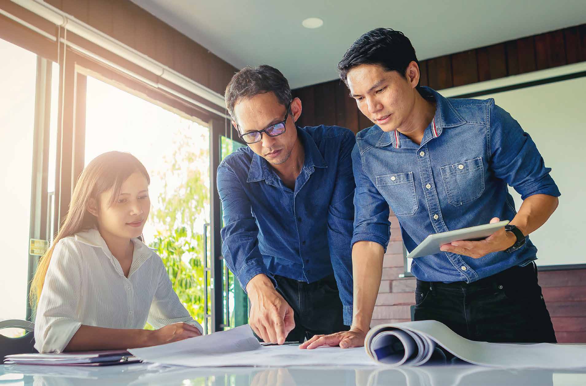 three architects reviewing building drawings