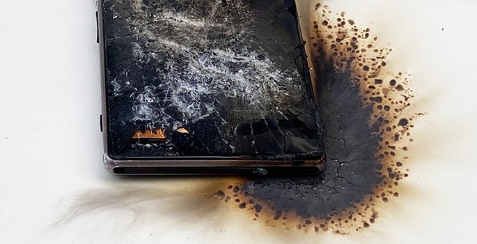 A cell phone charred from a lithium-ion battery fire