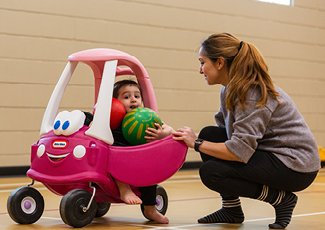 Child playing with caregiver in recreation centre.
