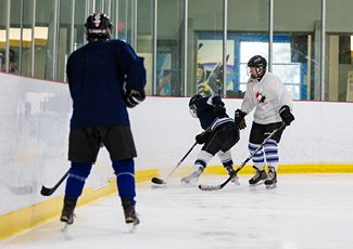 People playing ice hockey during recreational drop-in hockey.