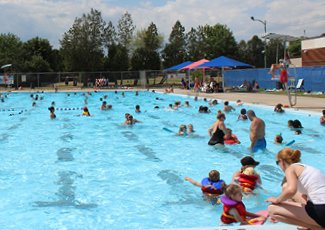 People swimming in an outdoor pool recreational swim drop-in.