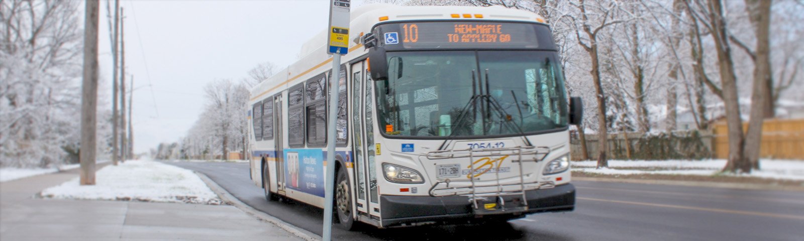 Image of a bus in a wintery scene, departing a stop on Route 10