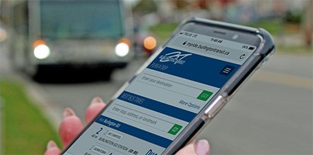 Person holding mobile device with MyRide app on display.
